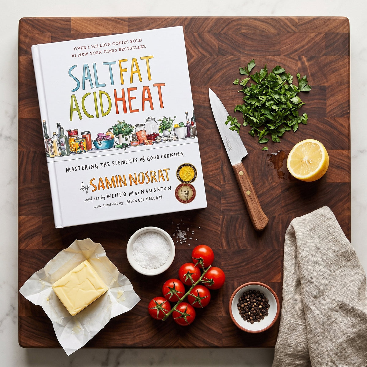 Salt, Fat, Acid, Heat on a butcher-block board with fresh ingredients
